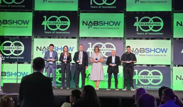 people on a stage holding trophies